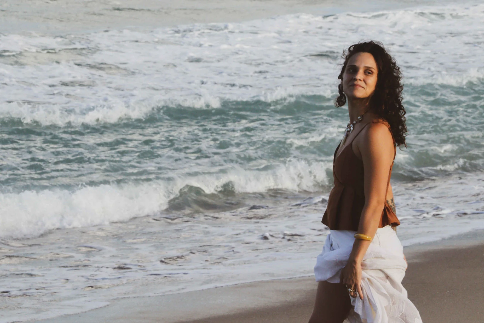 Mariana Tevah caminhando à beira-mar